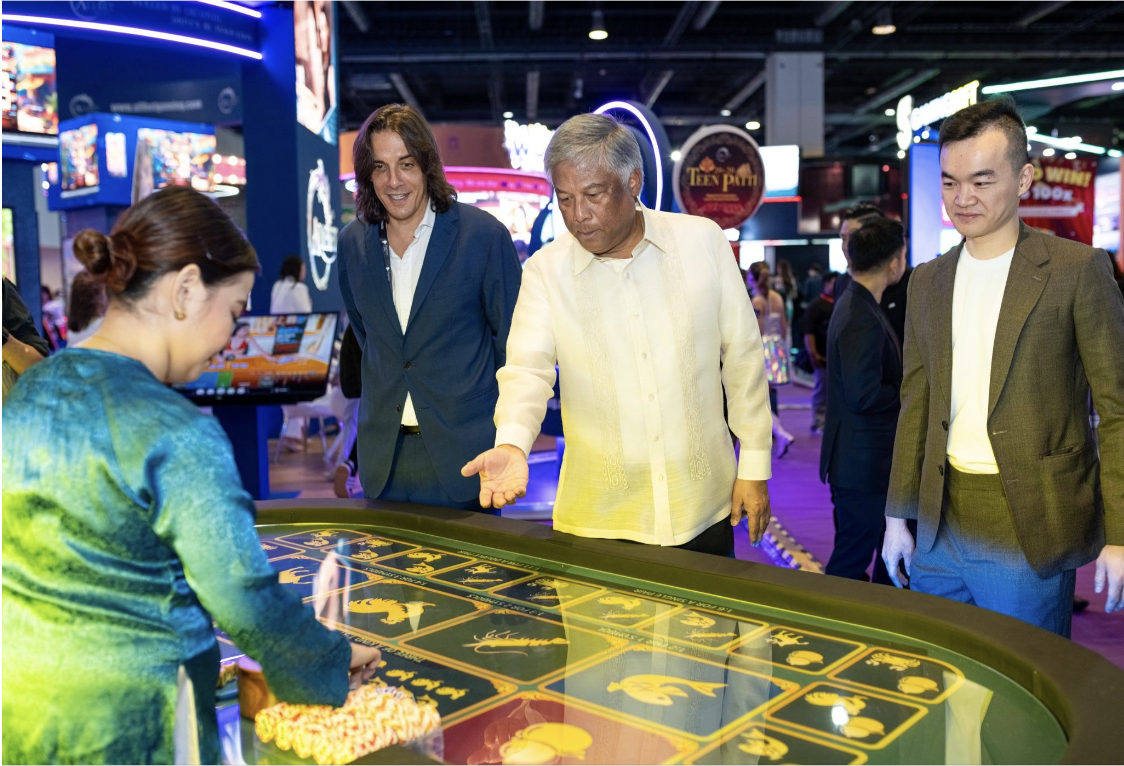 Pictured L/R Sigma founder Eman Pulis , Pagcor Director Alejandro H Tengcor And Sigma Asia CEO Neil Shih try their hand at Bau Cua at the Nautilus Games Booth 